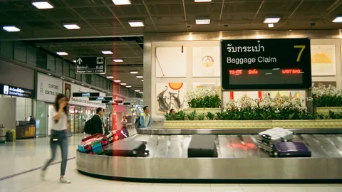 Bagasjehall med skiltet Baggage Claim og bagasje på båndet